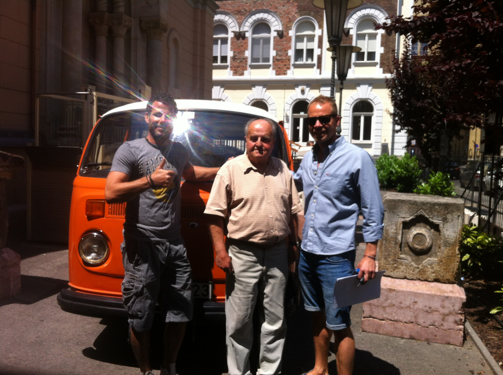 Mr. Thaly and two others standing in front of the orange VW T2